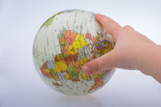 Child holding a globe in on a white background