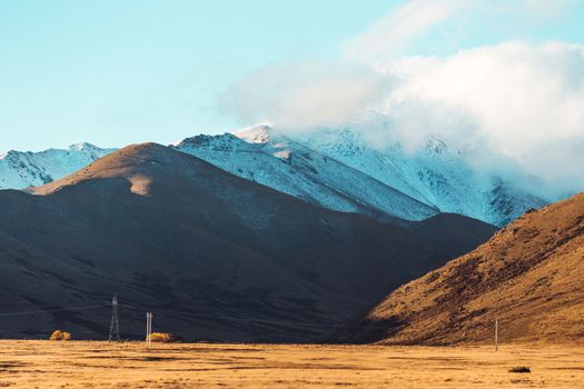 Road travel in the green mountains of New Zealand view from car window. Scenic peaks and ridges. Beautiful background of amazing nature.