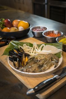 Raw seafood on plate with fruits and vegetables, healthy food, prawn, clam squid.