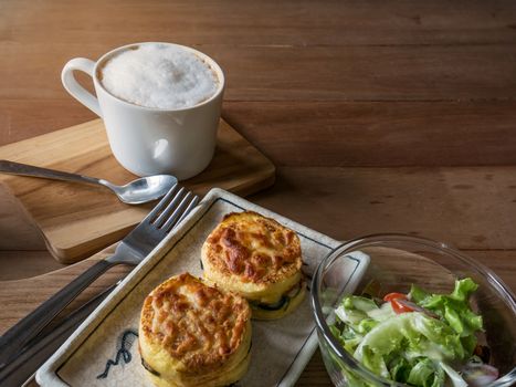 Set of food,salad ,baked spinach with cheese and coffee on wooden saucer