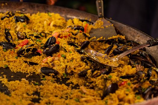 Large pan of seafood paella in a street tray