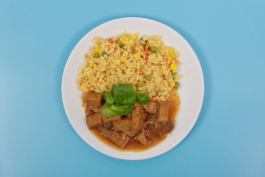 Tempeh with tomato sauce and millets on a blue background