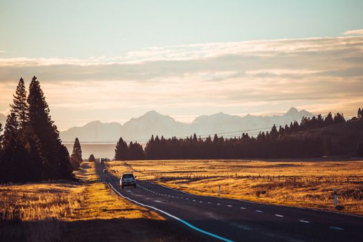 Road travel in the green mountains of New Zealand view from car window. Scenic peaks and ridges. Beautiful background of amazing nature.