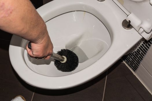 Cleaning a toilet with a toilet brush