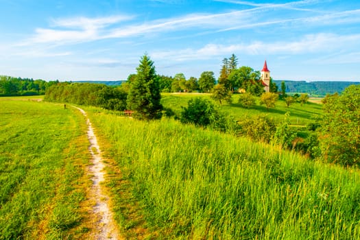 Small church in the middle of lush green spring landscape on sunny day. St. Peter and Pauls church at Bysicky near Lazne Belohrad, Czech Republic.