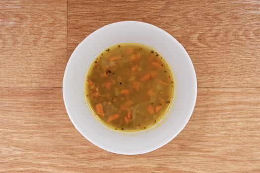 Lentil soup with carrots on a wooden table