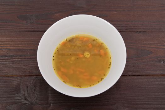 Lentil soup with carrots on a wooden table