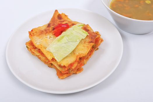 Lasagna with vegetables on a white background