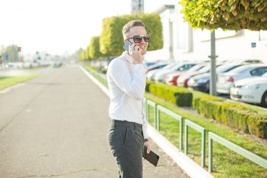 Businessman Man With Mobile Phone and Tablet computer in hands, In City, Urban Space