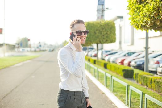 Businessman Man With Mobile Phone and Tablet computer in hands, In City, Urban Space