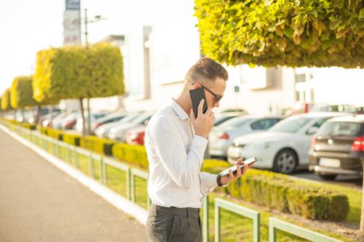 Businessman Man With Mobile Phone and Tablet computer in hands, In City, Urban Space