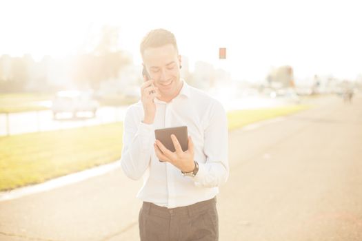 Businessman Man With Mobile Phone and Tablet computer in hands, In City, Urban Space