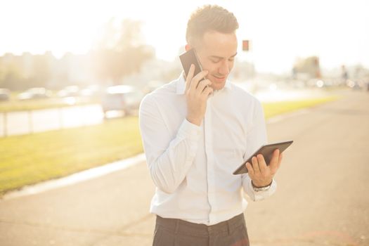 Businessman Man With Mobile Phone and Tablet computer in hands, In City, Urban Space