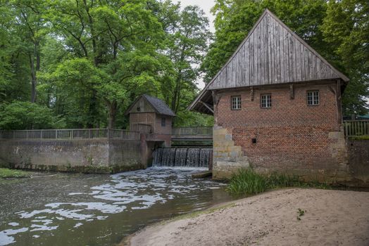 Small river with historic paddle wheel in Haarmuhle, Germany, Europe, this one is still working and more then 400 years old