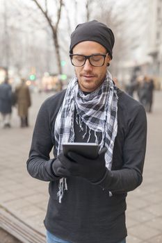 Young man reading messages and information using an i-pad tablet computer.