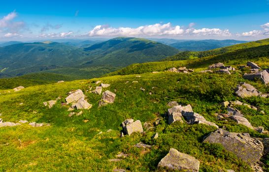 fresh summer forenoon scenery in mountains. beautiful with boulders on the grassy hill under the blue sky with some clouds.