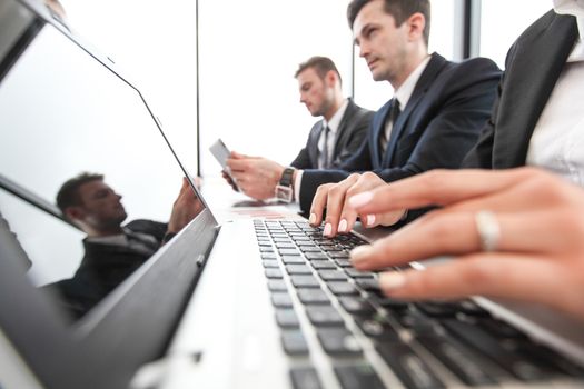 Mixed group of people at business meeting working together with documents and computers