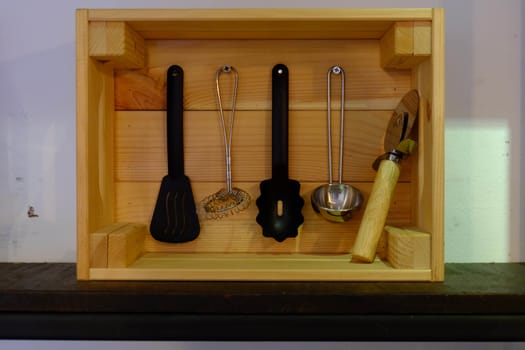 Kitchenware in a wooden box with a rectangular shape.