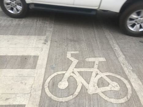 The car drive through bicycle road sign on concrete floor.