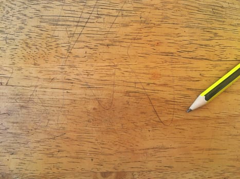 Green and yellow pencil on bright wood floor