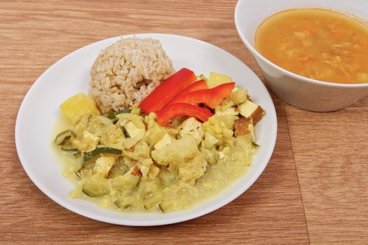 Cauliflower mixture with curry and rice on a wooden table