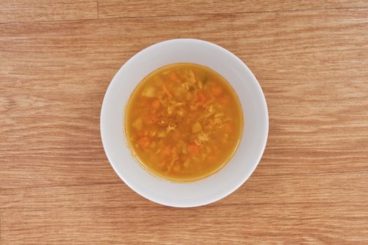 Groat soup with vegetables on a wooden table