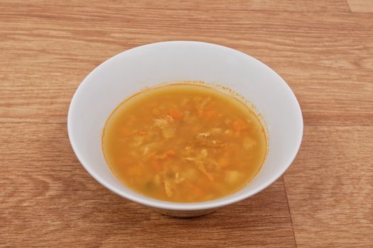 Groat soup with vegetables on a wooden table