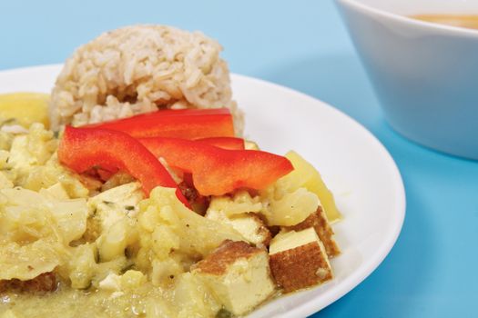 Cauliflower mixture with curry and rice on a blue background