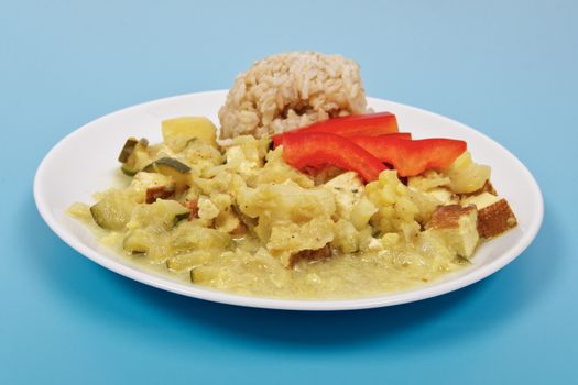 Cauliflower mixture with curry and rice on a blue background