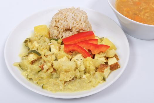 Cauliflower mixture with curry and rice on a white background