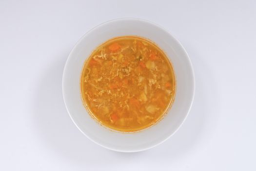 Groat soup with vegetables on a white background