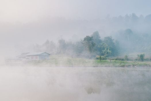 Cottage in the village among mountain and fog