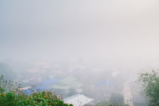 Cottage in the village among mountain and fog