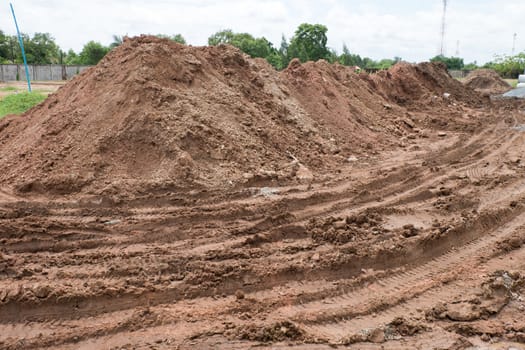 Dirty dirt road with puddles and mud in countryside in Thailand.