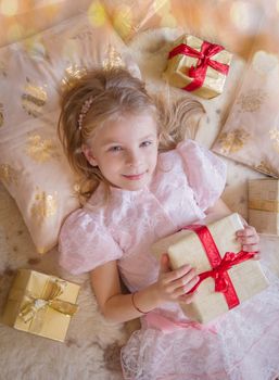 Top view of smiling female kid with lots of presents