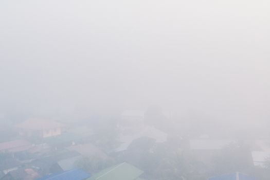 Cottage in the village among mountain and fog