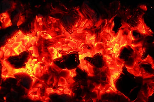 Ash fire in dark night. Campfire coals burn in the darkness. Ejection lava