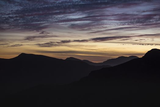 Mountains silhoutted by colorful sunset