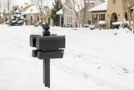 Black mailboxes on a snow-covered street