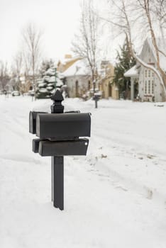 Black mailboxes on a snow-covered street