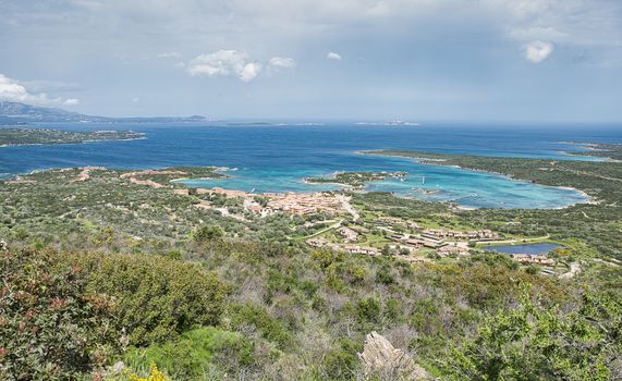 view from the point of the church Santuario Nostra Signora del Monte  down to maarinella village with resort and the bay with blue water