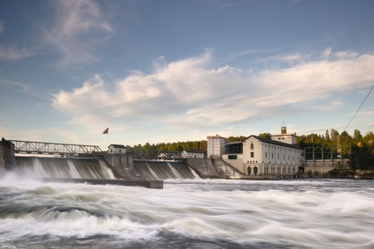 Rånåsfoss dam and power station in Akershus, Norway. Water is flowing over the dam. Long exposure.