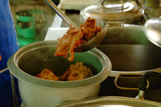 The ladle is drained porksoft in a bowl ,Cooking noodle in thailand,the noodles pork and beef.