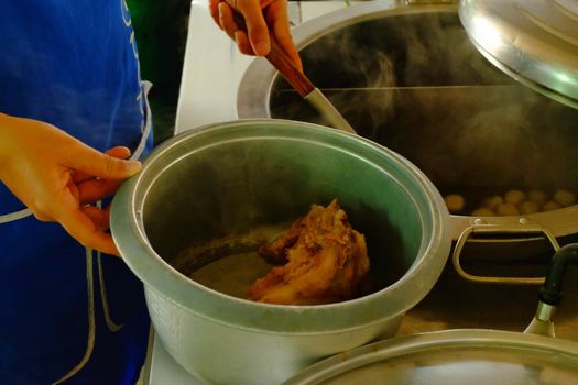 The ladle is drained porksoft in a bowl ,Cooking noodle in thailand,the noodles pork and beef.