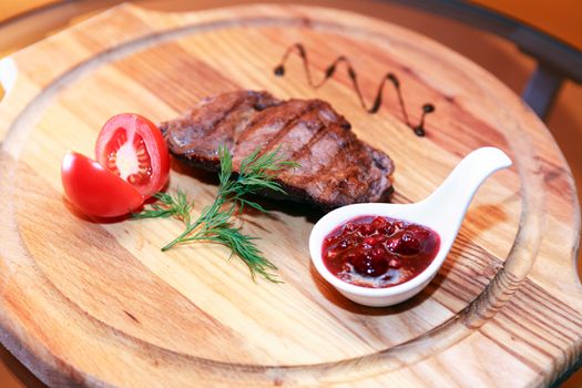 Grilled meat and vegetables on wooden board