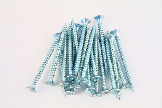 Set of screws for construction on a white background, metal screw, iron screw, chrome screw, screws as a background, wood screw. Close-up.