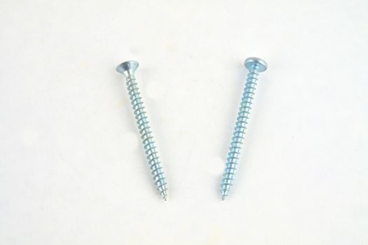 Set of screws for construction on a white background, metal screw, iron screw, chrome screw, screws as a background, wood screw. Close-up.