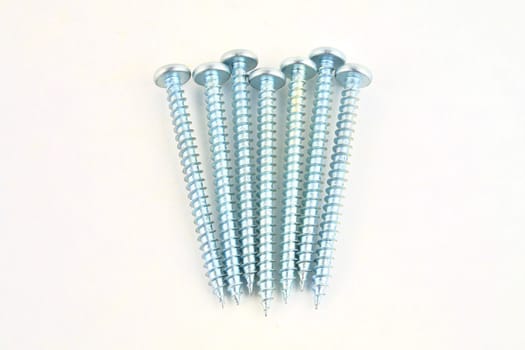 Set of screws for construction on a white background, metal screw, iron screw, chrome screw, screws as a background, wood screw. Close-up.