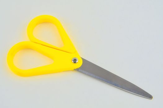 Yellow scissors isolated on a white background. Top view.