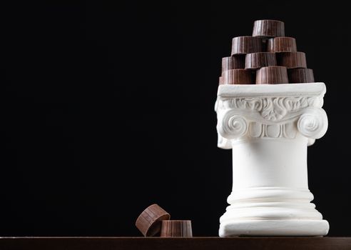 Stack of Fine Artisan Chocolates Stacked On White Pillar Column.